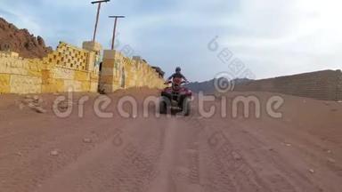 在埃及沙漠里，女人骑着一辆四方自行车。 动中的动态视图..